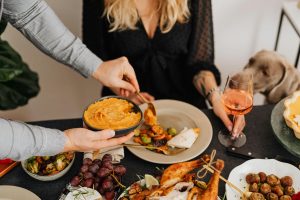 Thanksgiving family dinner with dog looking at all the food on the table